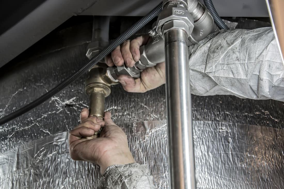 Engineer connecting heating pipework for a combi boiler in a Newcastle home
